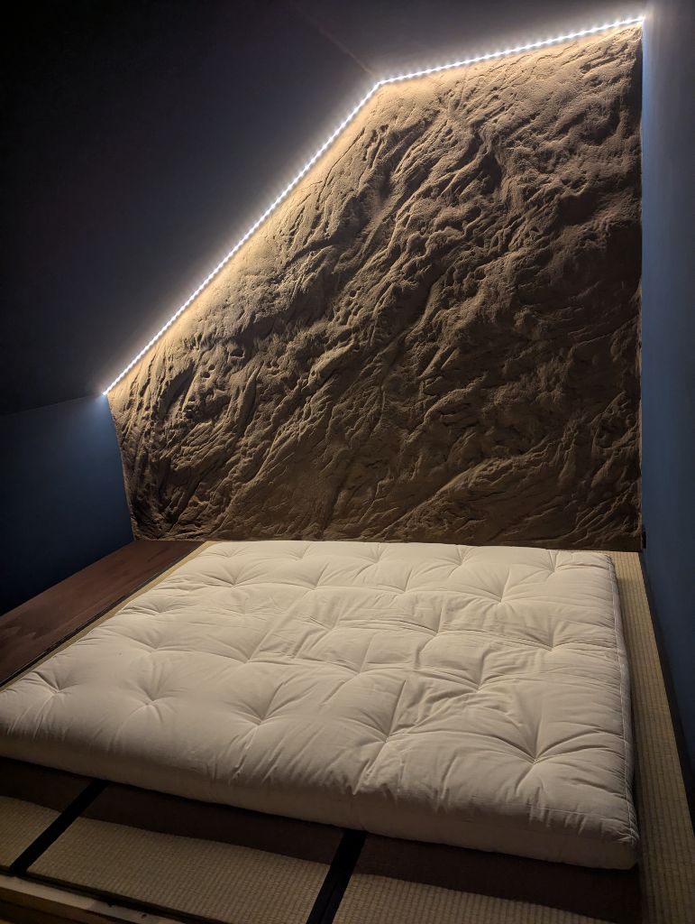 Wandgestaltung in Felsoptik als Bett-Rückwand