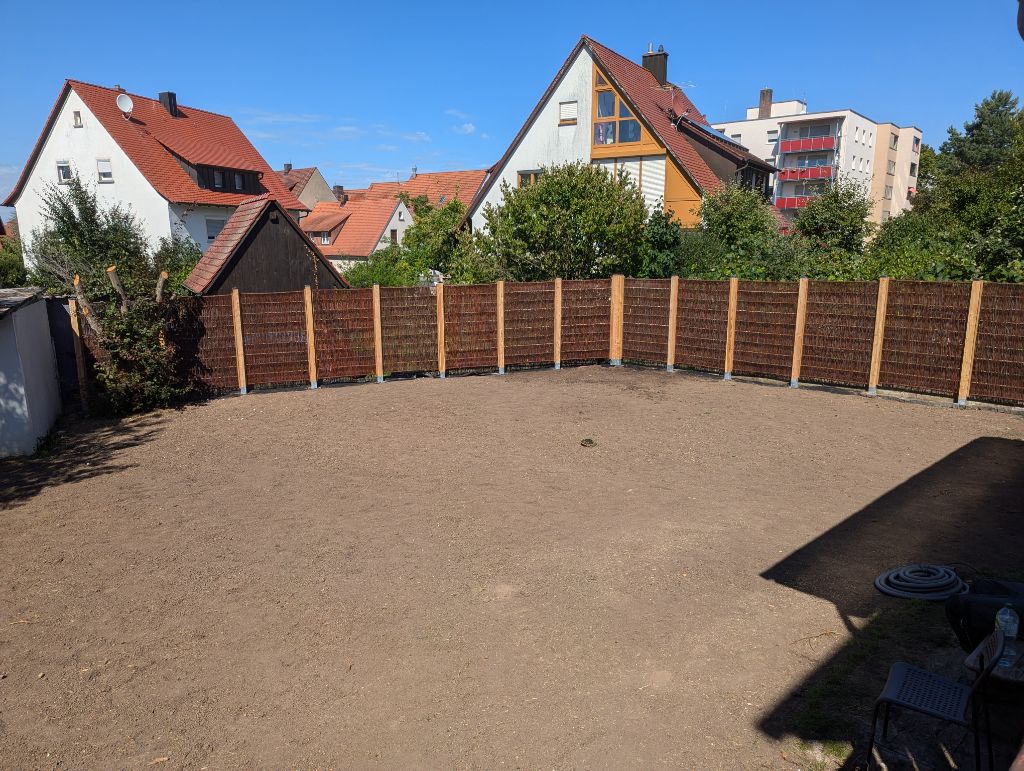 Garten nachher, aufgeräumte Fläche mit neuem Zaun als Umfassung