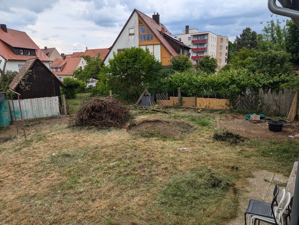 Garten vorher mit Astschnitt, Grünabfällen und ungepflegter Rasenfläche